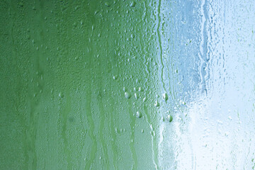 Blue background of natural water condensation, window glass with high air strong humidity, large drops drip. Collecting and streaming down - obrazy, fototapety, plakaty