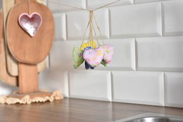 hearts sewn from fabric with their own hands hang on a rope in the kitchen