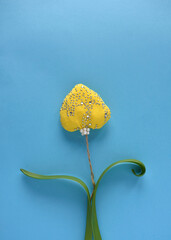yellow heart with sparkles on a simple rope on blue background