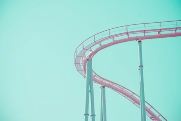 Zelfklevend Fotobehang Amusementspark Roze pastel looping achtbaan op blauwe hemel zonnige dag retro toon. Geniet van het concept van de reisvakantie.