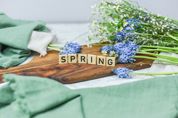 Frühling Dekoration, Flatlay mit Traubenhyazinthen, Muscari, Holzbrett und Schriftzug „Spring“