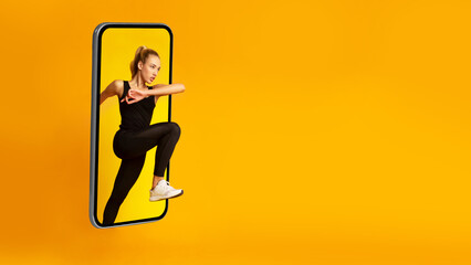 Athletic Lady Jumping From Huge Smartphone Screen Exercising, Yellow Background