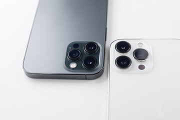 a white smartphone with three cameras lies on a  white background