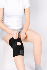 Knee Support Brace on leg isolated on white background. Elastic orthopedic orthosis. Anatomic braces for knee fixation, injuries and pain. Protective knee joint bandage sleeve. Trauma, rehabilitation