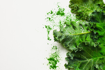 Green leaves of kale and kale powder on white background. copy space for text