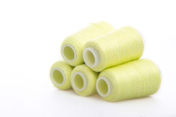 Fototapeta na wymiar Yellow spool of thread isolated on white background. Skein of woolen threads. Yarn for knitting. Materials for sewing machine. Coil