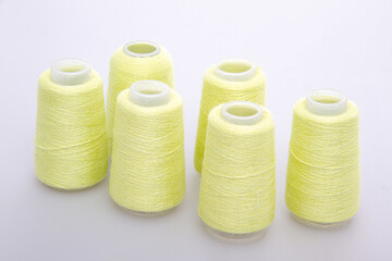 Yellow spool of thread isolated on white background. Skein of woolen threads. Yarn for knitting. Materials for sewing machine. Coil