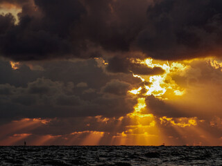 Wschód słońca nad morzem na zachmurzonym niebie. - obrazy, fototapety, plakaty
