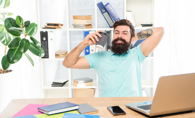 Happy businessman drinking coffee relaxing at office desk, break
