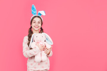 happy easter teen girl in bunny rabbit ears and pajamas play with toy, copy space, easter