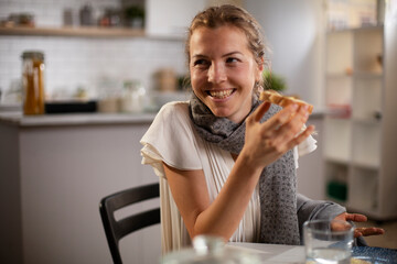 Beautiful woman enjoying in breakfast. Happy young woman eating sandwich at home..