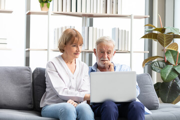senior couple using laptop computer on sofa