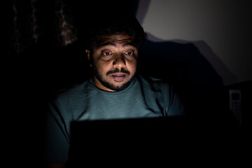 young corporate employee late night busy using laptop on bedroom - concept of overnight working, stressed out and work from home lifestyle