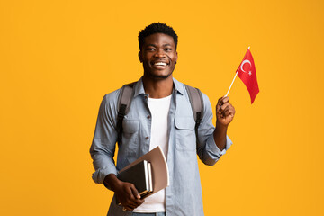 Happy black guy student showing flag of Turkey