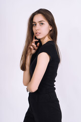 Fototapeta premium Young Female model in studio. high fashion portrait of young elegant woman. skinny black pants, black heels shoes. 