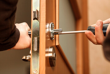 Handle Door Fixing, Repairing Door Handle with Screwdriver. © Maryana