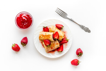 Sweet breakfast - rolled pancakes with strawberry and berry sauce