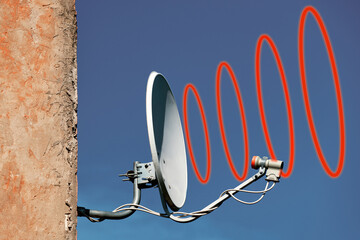 TV antenna on the wall of the house . Close-up on a blue sky background