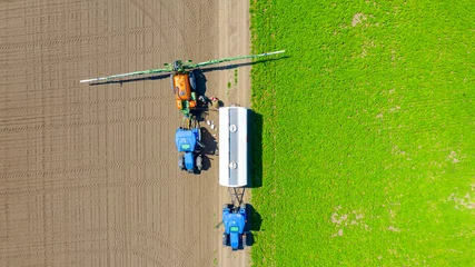 Tuinposter Aerial view on tractor with sprayer came for reload, herbicide and pesticide © Roman_23203