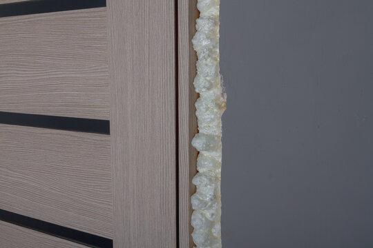 Installing the door in the room in the doorway, fixing the door with mounting foam