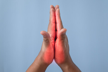 Office syndrome concept. Fingers are massaged after working. Pain symptom area is shown with red color. Close up shot isolates on blue background.