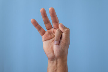 Office syndrome concept. Index finger is stretched after working. Close up shot isolates on blue background.