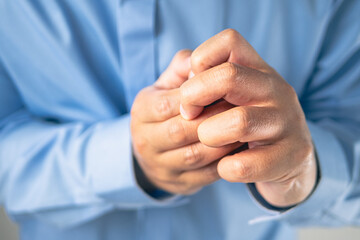 Fingers pain in office syndrome concept. Salaryman wears a blue shirt. Medium close up shot.