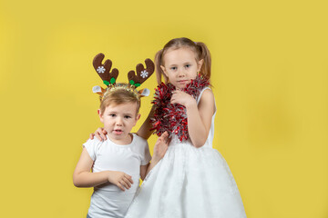 Portrait of children in christmas reindeer costume and dress looking at camera