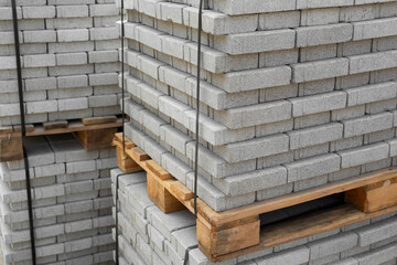 Stack of contemporary stone Paving slabs pavers. Building material on pallet for road paving. Sidewalk tile. Construction site