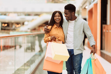 Portrait of black couple walking with shopping bags