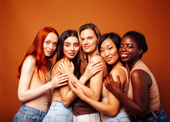 Obraz premium young pretty caucasian, african, scandinavian woman posing cheerful together on brown background, lifestyle diverse nationality people concept