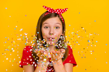 Photo of cute adorable girl send you confetti celebrate holiday event party isolated on yellow...