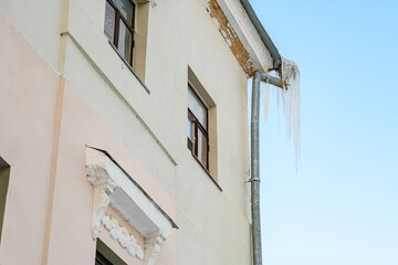 Fototapeta na wymiar Ice icicles dangerously hanging from the roof