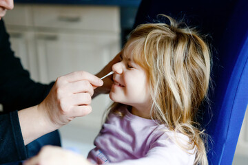 Father making nasal home corona virus tast to little girl, preschool child. Daughter and dad take...