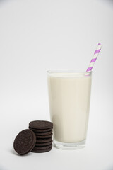 Chocolate cookies with milk in a glass on a white background