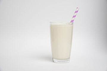 glass of milk with purple straw isolated on a white background