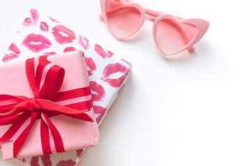 Gift boxes with red bow with heart shaped sunglasses on the white background. Valentine's day concept frame. Copy space