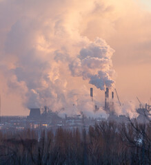 Smoke from the chimneys of a steel plant at sunset