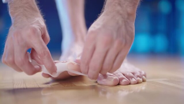 Person put on silicone toe corrector spreader on feet close-up 4K