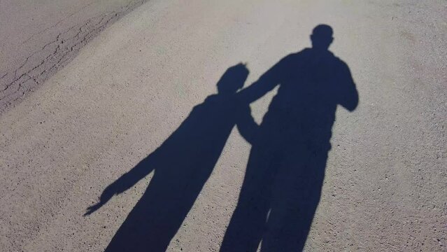 child traffickers, child theft, child abuse,adult and child shadow walking on the road,