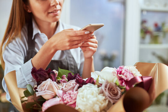 Busy florist photographing freshly made bouquet for social media
