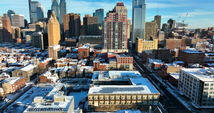 Philadelphia city skyline in winter snow. City Hall and homes on South Broad Street. Bright sunny day aerial truck shot.