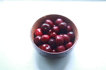 Bowl of ripe sweet cherries on the windowsill.