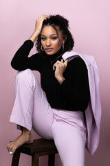 Portrait of a stunning young black successful business woman in a pink studio