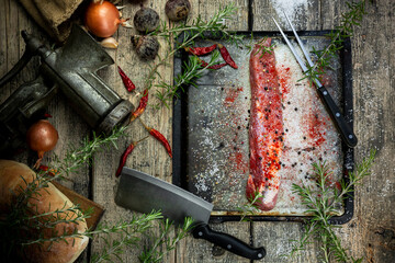 Raw pork tenderloin with rosemary and spices in the kitchen. Top view