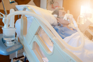 patient with endotracheal tube resting on bed in hospital. blurred background