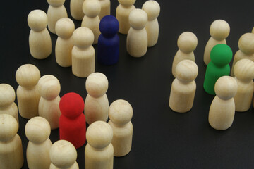 Wooden people figures divided into groups with leaders. Team collaboration and coordination business concept.