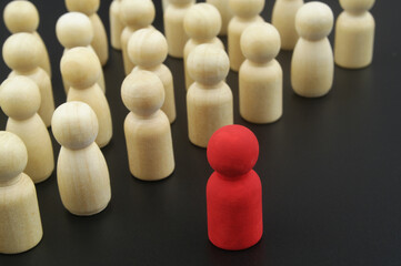 Management concepts. Wooden figure stand in formation and leader standing forward