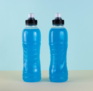 Close Up Isotonic Energy Blue Sports Drink In Plastic Bottles On A Blue Background. Allows You To Maintain The Most Optimal Balance Of Water, Salts And Electrolytes During Sports