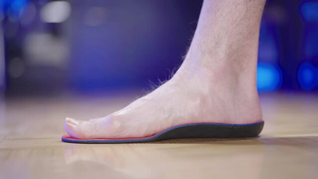 Person foot step inside the arch support insole close-up 4K